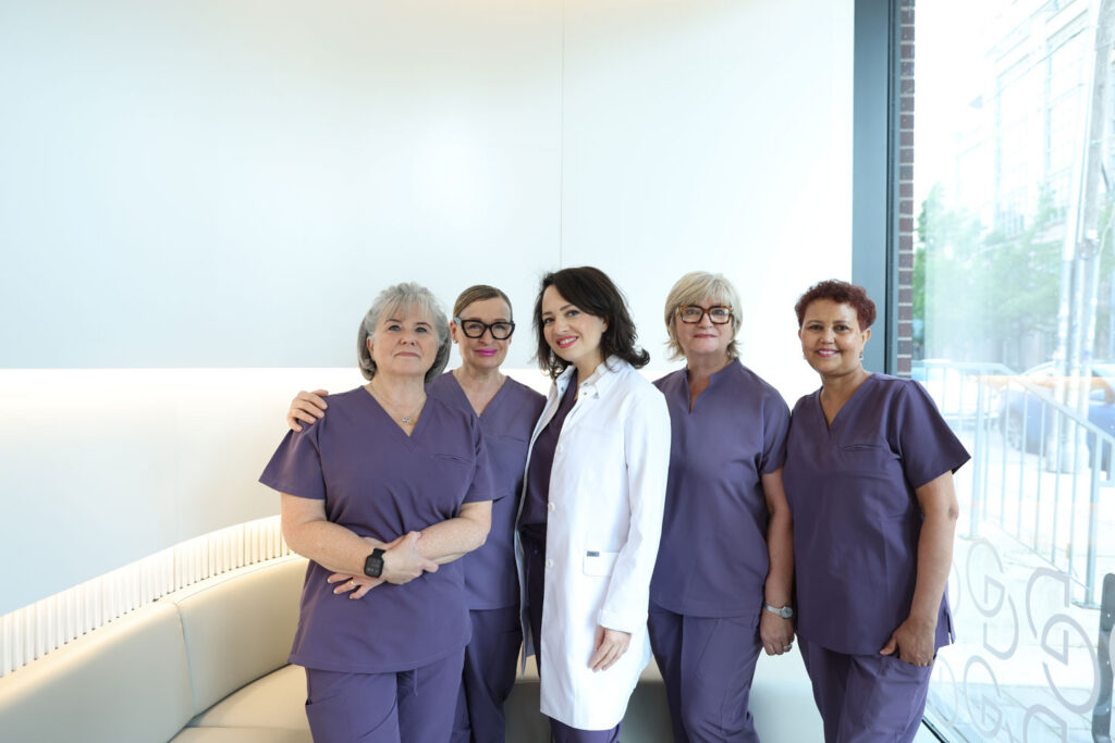 Dentist and a group of dental hygienists indoors in scrubs